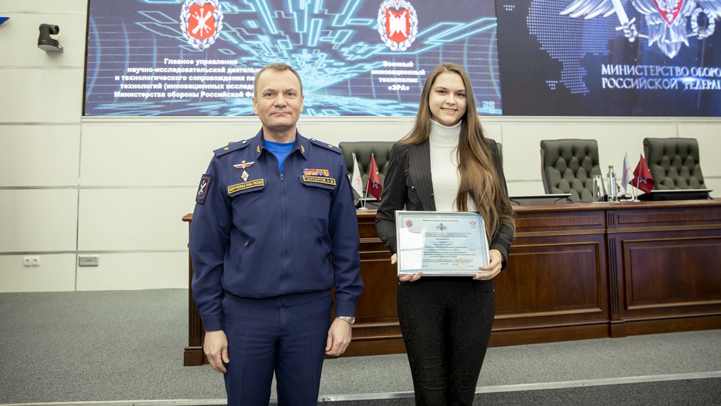 Доктор военных наук генерал-майор Андрей Гончаров вручает награду студентке Елене Юзько.