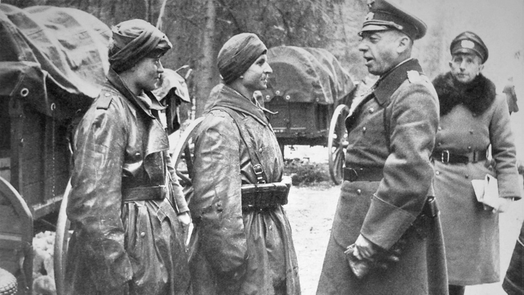 Генерал-полковник Георг фон Кюхлер разговаривает с двумя мотоциклистами.