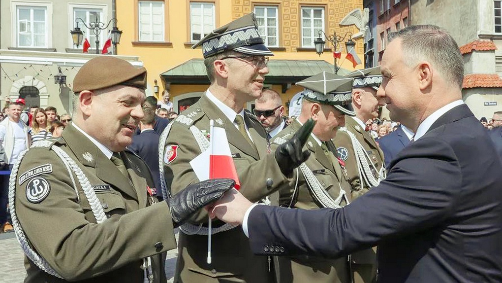 Анджей Дуда вручает флажки польским военным.