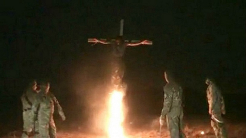 Нацисты сжигают ополченца Донбасса на кресте.