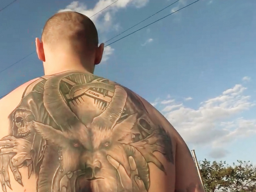 Оккультные татуировки на спине снайпера из «Азова»*.