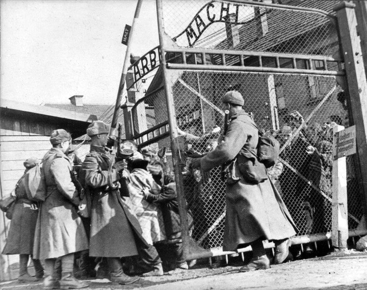 Советские солдаты открывают ворота концлагеря Освенцим, освобождая заключенных.