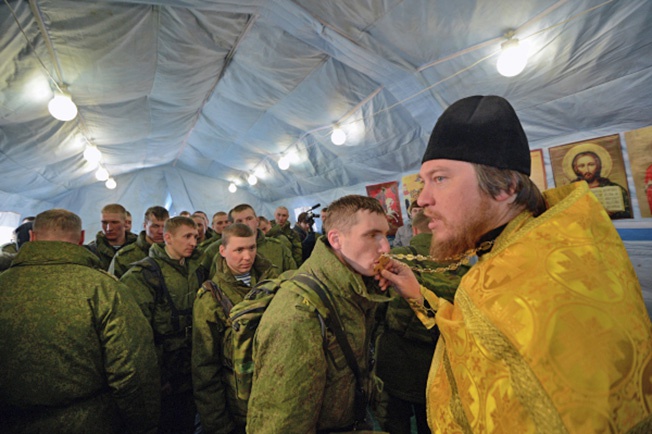 Главный военный священник отец Михаил проводит службу в мобильном храме.