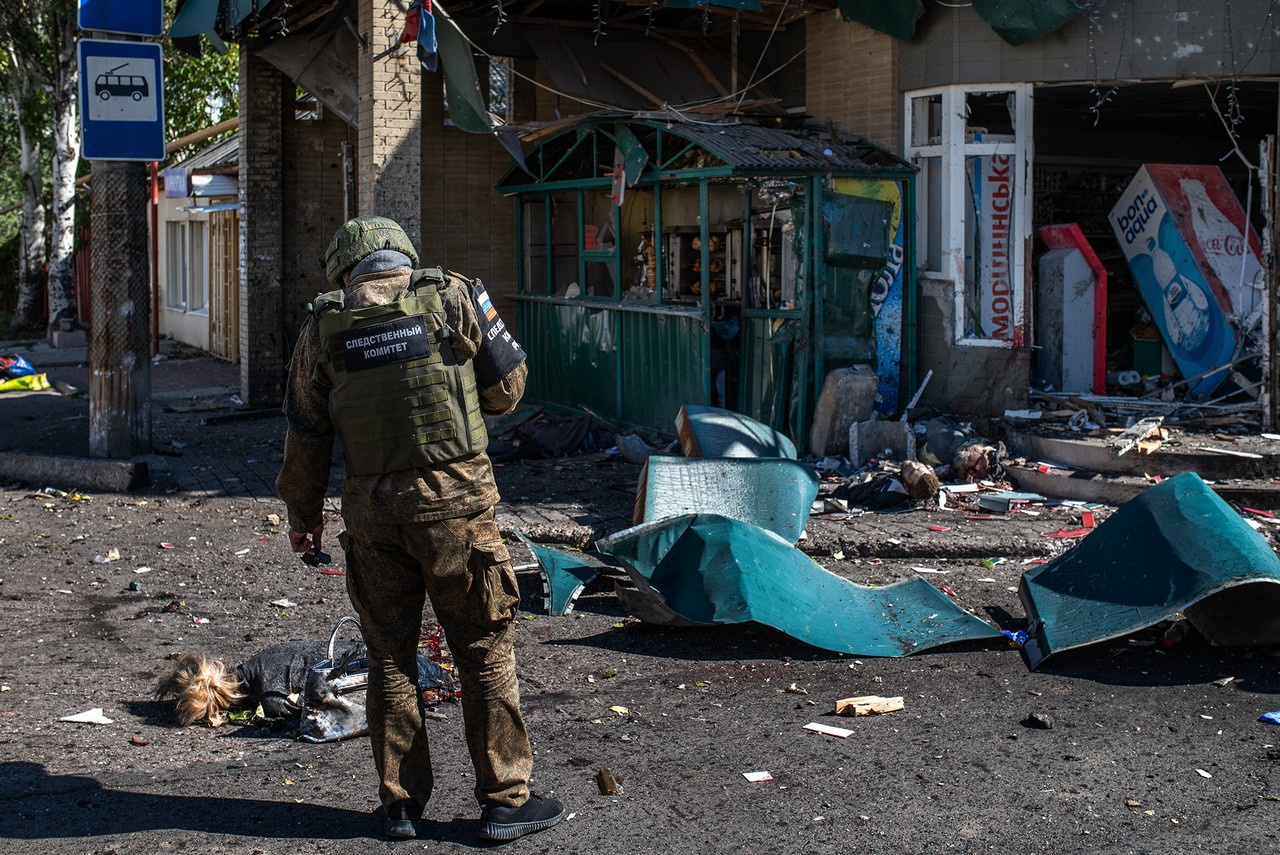 От молодой белокурой женщины осталась ровно половина, рядом стоит уцелевшая дамская сумка.