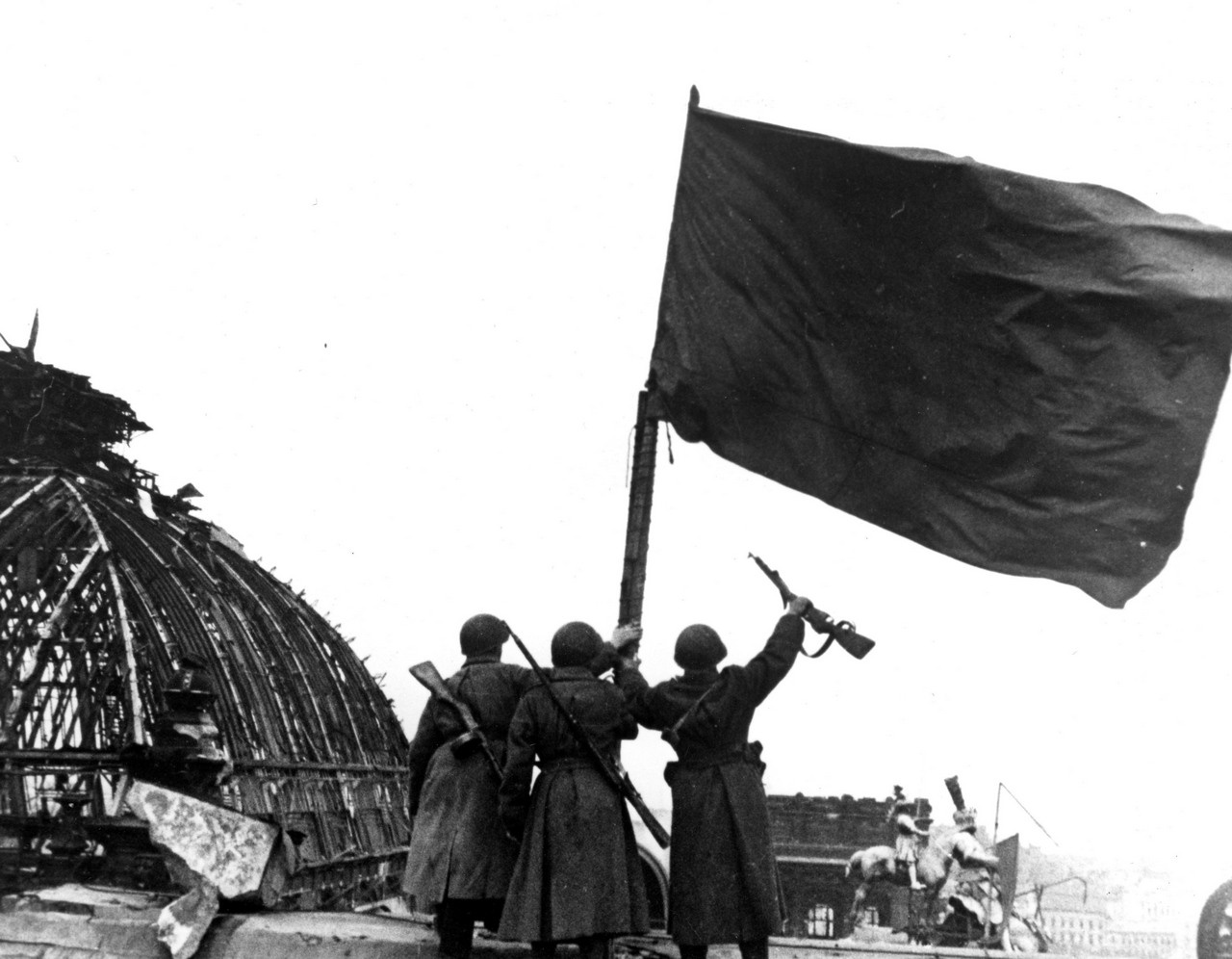 Бойцы Советской Армии и одно из знамен, водруженных над Рейхстагом.