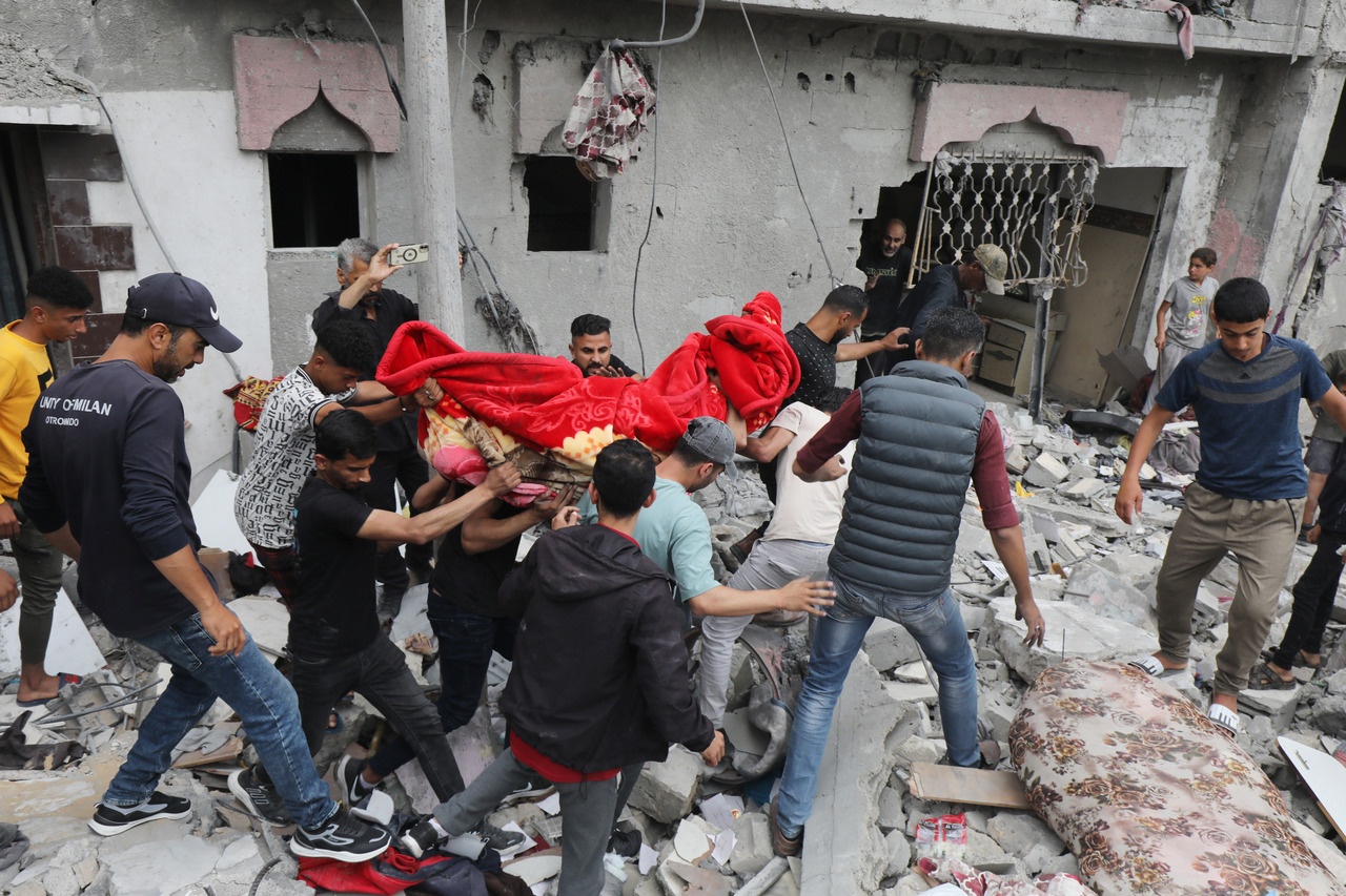 Палестинцы разбирают завалы разрушенного дома в поисках тел погибших и выживших после израильского авиаудара.