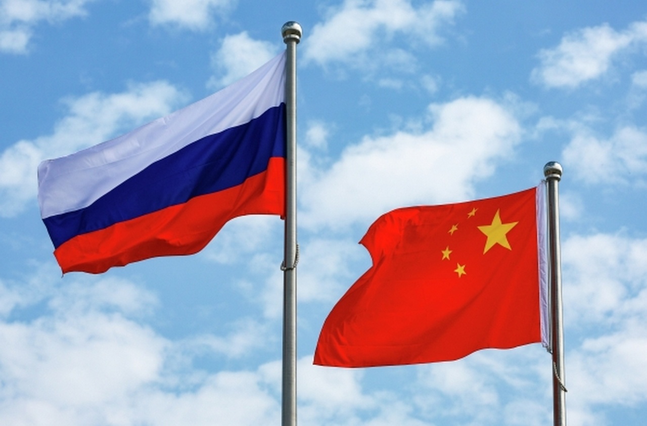 Флаги России и КНР, поднятые в аэропорту Биньхай города Тяньцзинь перед прибытием президента РФ Владимира Путина с официальным визитом в КНР.