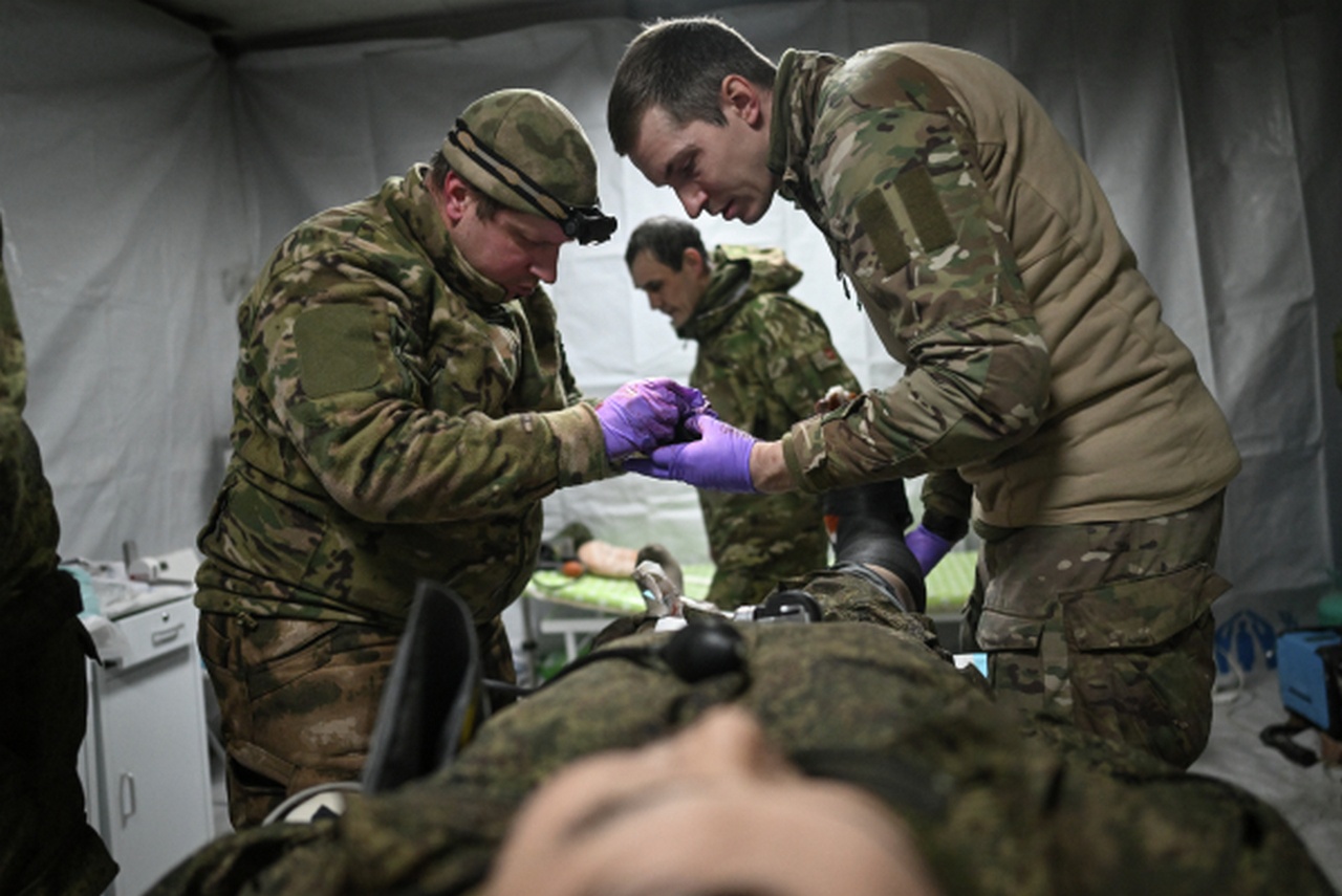 Военные врачи оказывают медицинскую помощь раненому.