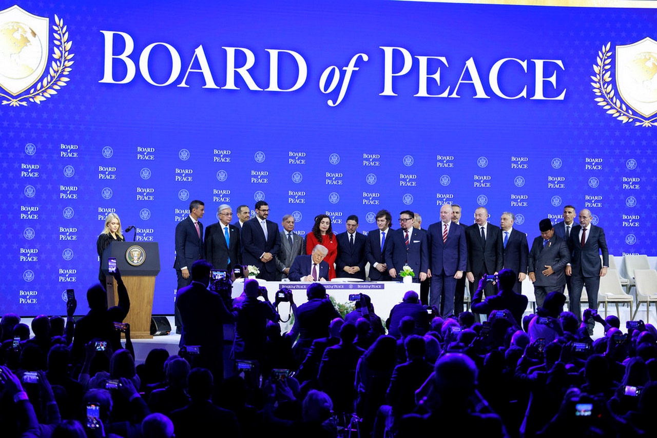 Участники «Совета мира» наблюдают, как Трамп подписывает хартию организации.